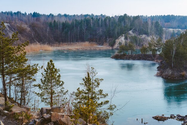 Hermosa cantera cerca del lago cubierto de hielo fino