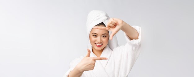 Hermosa cara de mujer y ella haciendo marco con las manos con el concepto de piel saludable para el cuidado de la piel belleza asiática