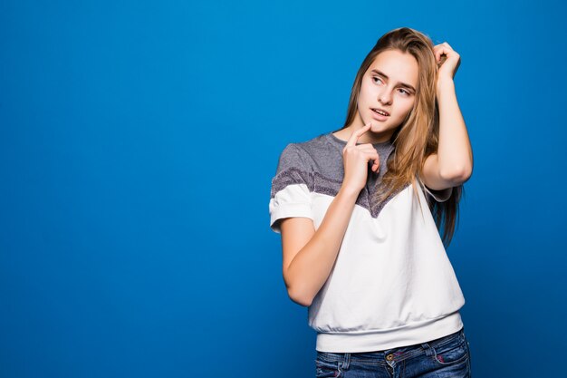 Hermosa chica adolescente alegre en suéter blanco sobre fondo azul