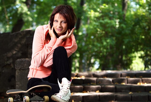 Hermosa chica adolescente con auriculares en el parque