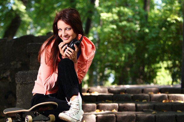 Hermosa chica adolescente con auriculares en el parque