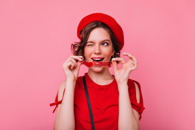 Hermosa chica alegre disfrutando dedicada al día de San Valentín. Atractiva dama caucásica con peinado ondulado sonriendo.