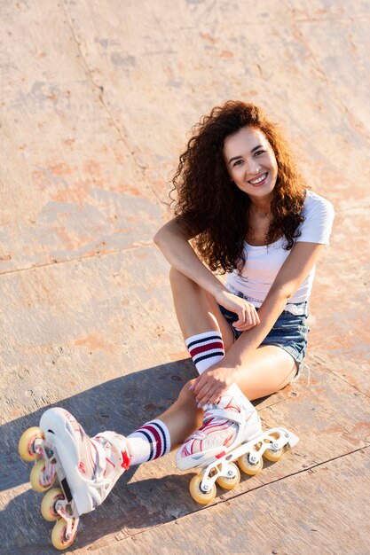 Hermosa chica de alto ángulo con el pelo rizado posando