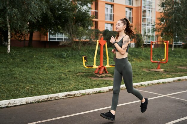 Hermosa chica atlética corre alrededor del estadio