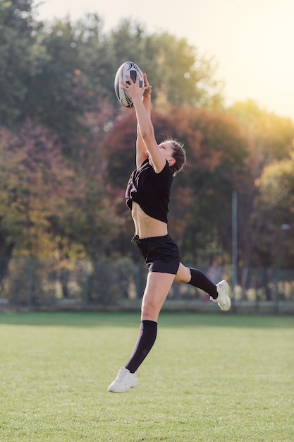 Hermosa chica atrapando una pelota de rugby