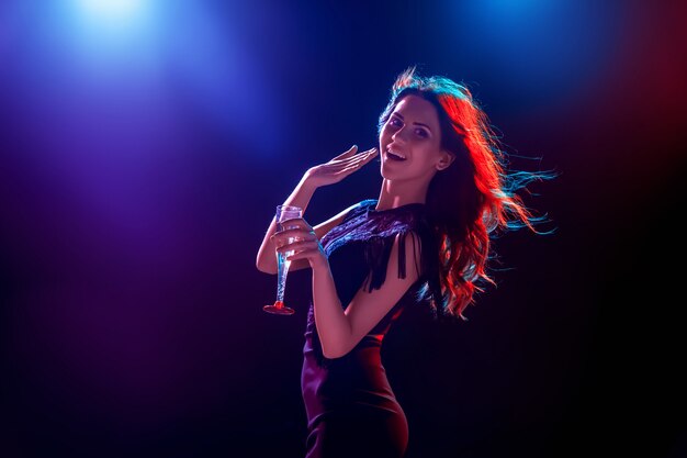 La hermosa chica bailando en la fiesta bebiendo champaña