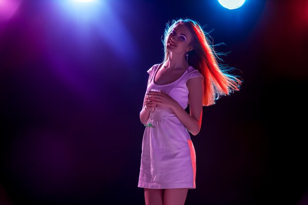 La hermosa chica bailando en la fiesta bebiendo champaña