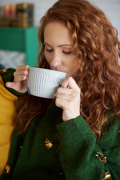 Hermosa chica bebiendo té en la mañana de otoño