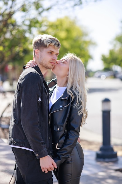 Una hermosa chica besando a su novio en el parque.