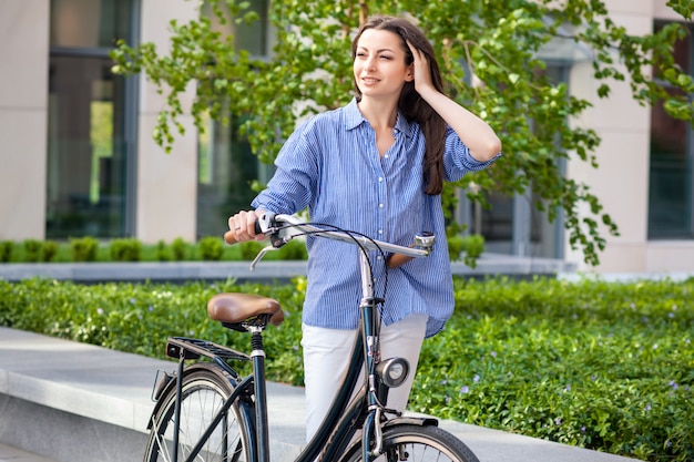 Hermosa chica con una bicicleta en el camino