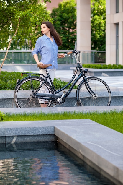 Hermosa chica con una bicicleta en el camino