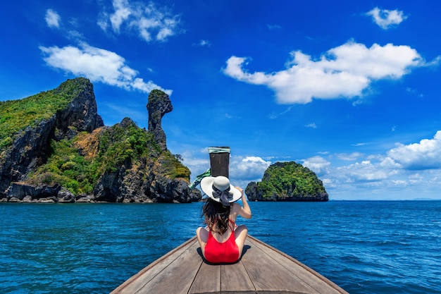 Hermosa chica en bikini rojo en barco en la isla de Koh Kai, Tailandia.