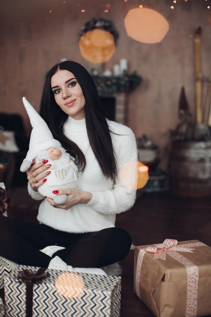 Hermosa chica con cabello largo y oscuro con pequeña enana blanca