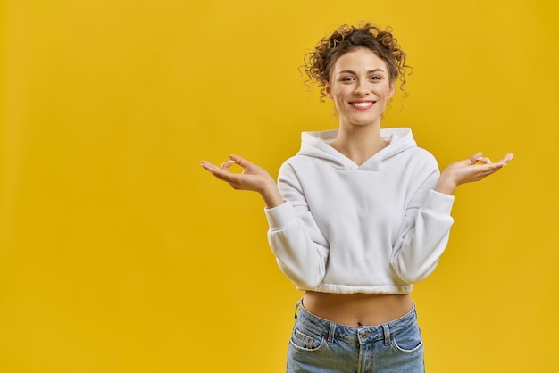 Foto gratuita hermosa chica con cabello rizado sonriendo mirando a la cámara