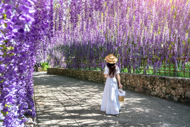 Hermosa chica caminando en el túnel de la flor morada en Chiang Rai, Tailandia