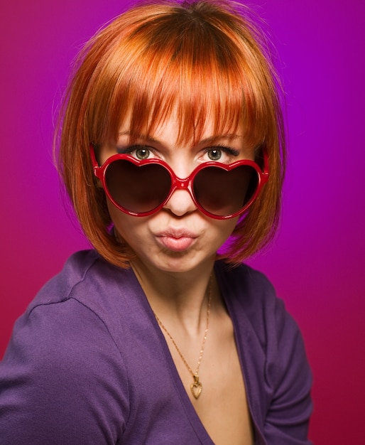Hermosa chica de color rojo con gafas de sol