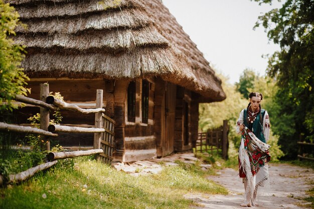 Hermosa chica en un colorido traje tradicional camina por el pueblo