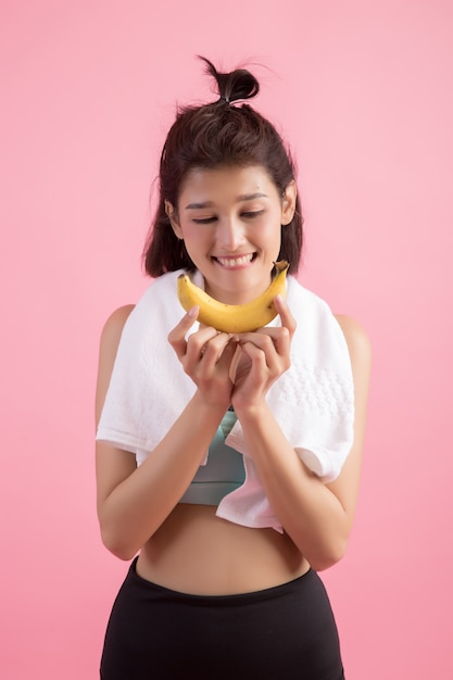 Foto gratuita hermosa chica comiendo bananas después de hacer ejercicio para controlar el peso.