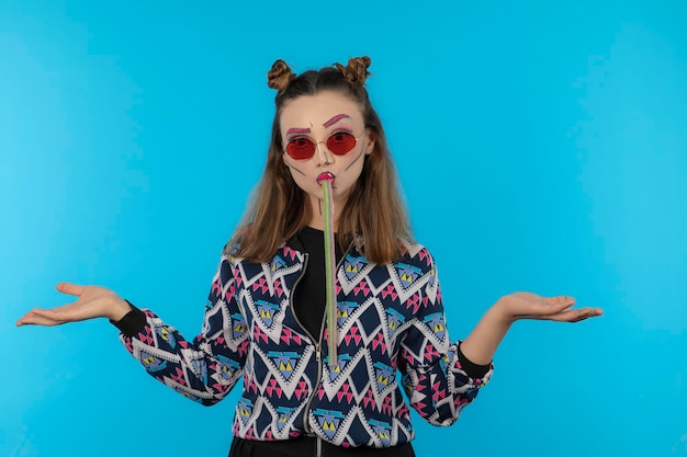 Hermosa chica comiendo dulces y abriendo las manos. foto de alta calidad