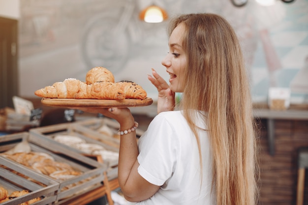 Hermosa chica compra bollos en la panadería