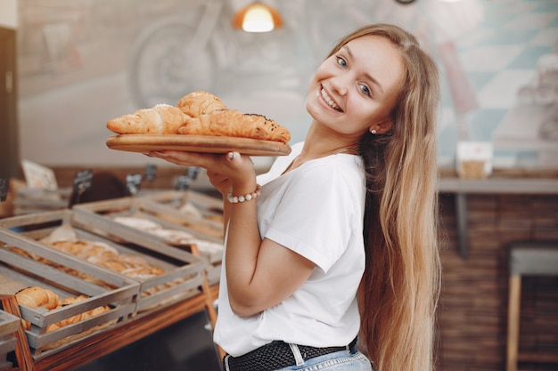 Hermosa chica compra bollos en la panadería