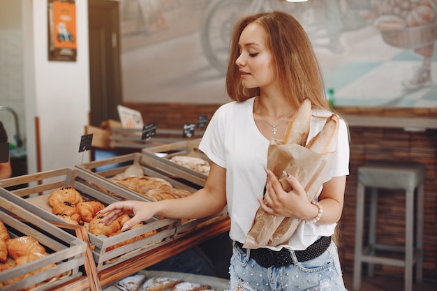 Hermosa chica compra bollos en la panadería