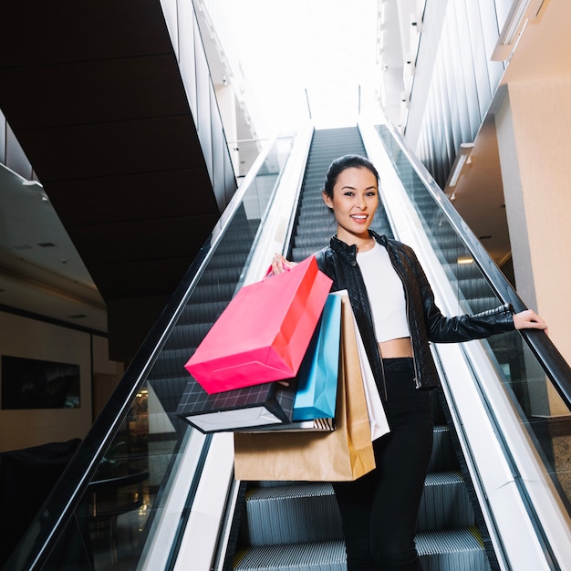 Hermosa chica con las compras en bolsas