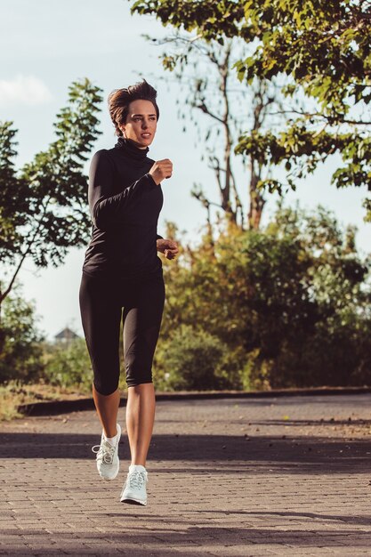 Hermosa chica corriendo en el parque.