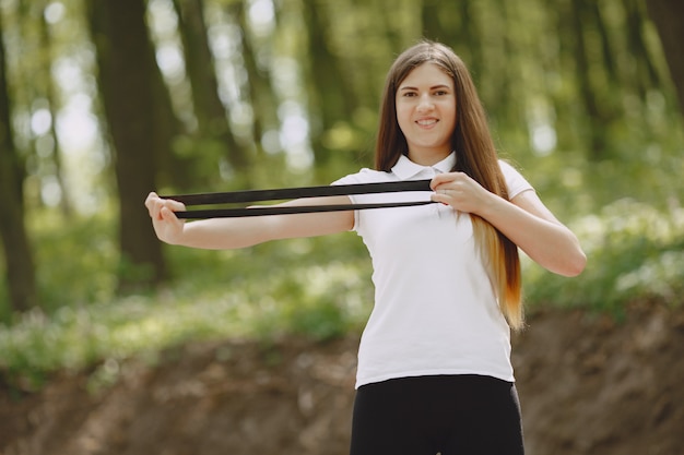 Hermosa chica deportiva en un bosque de verano