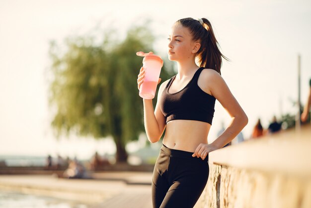 Hermosa chica deportiva en un parque de verano