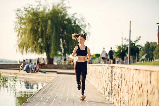 Hermosa chica deportiva en un parque de verano