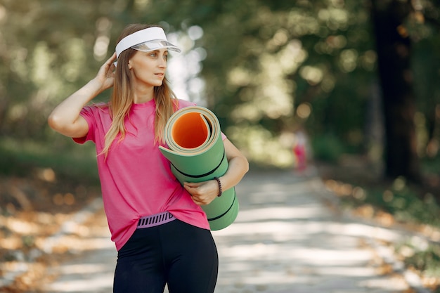 Hermosa chica deportiva en un parque de verano