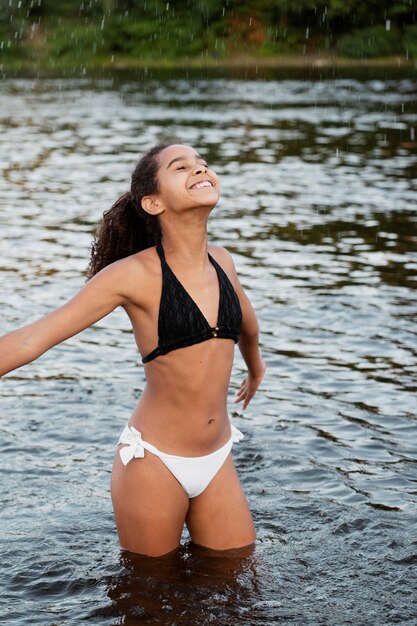 Hermosa chica divirtiéndose al aire libre en el lago