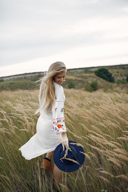 Foto gratuita hermosa chica elegante en un campo de trigo de otoño