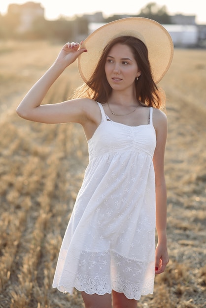 Hermosa chica elegante en un campo de trigo de otoño