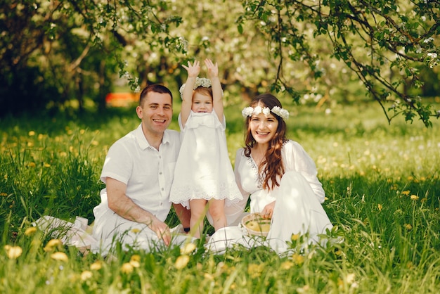 hermosa chica embarazada en un vestido blanco largo con su novio y su pequeña hija