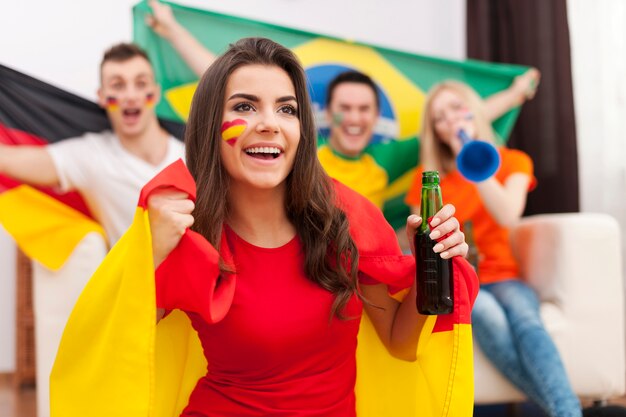Hermosa chica española con sus amigos animando partido de fútbol