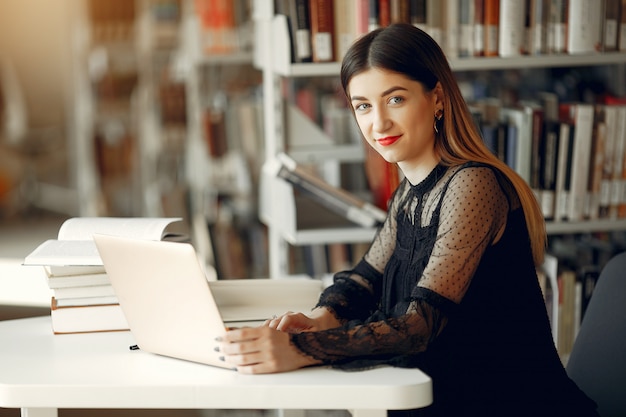 Hermosa chica estudia en la biblioteca