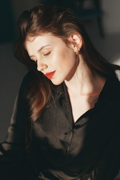 Hermosa chica en un estudio. Mujer elegante con un vestido negro.