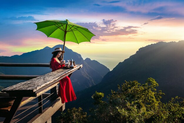 Hermosa chica haciendo café por goteo en el mirador del amanecer en la aldea de Pha Hi, provincia de Chiang Rai, Tailandia