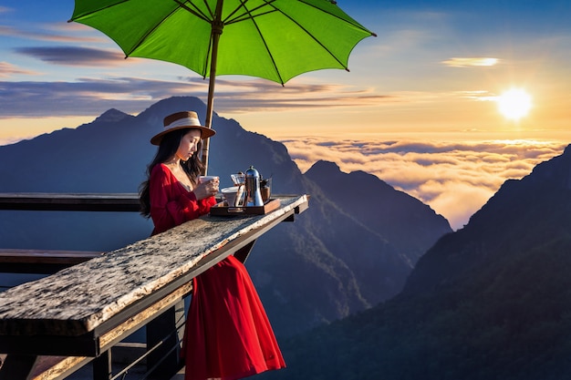 Hermosa chica haciendo café por goteo en el mirador del amanecer en la aldea de Pha Hi, provincia de Chiang Rai, Tailandia