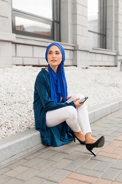 Hermosa chica con hijab sentada afuera