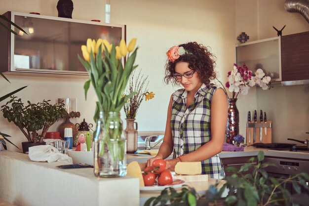 Hermosa chica hispana rizada cocinando en su cocina.