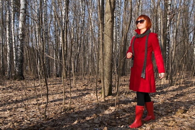 Hermosa chica llevaba abrigo rojo y gafas de sol