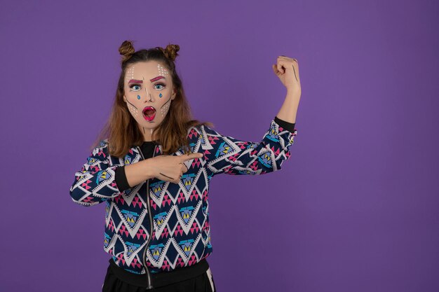 Hermosa chica con maquillaje de fantasía sobre fondo morado. foto de alta calidad