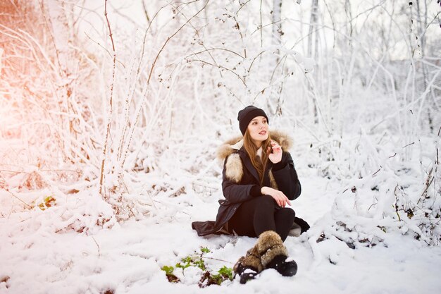 Foto gratuita hermosa chica morena en ropa de abrigo de invierno modelo en chaqueta de invierno y sombrero negro