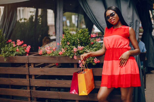 Hermosa chica negra con bolsas de compras en una ciudad