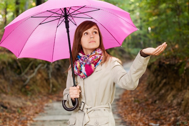 Hermosa chica con paraguas buscando lluvia