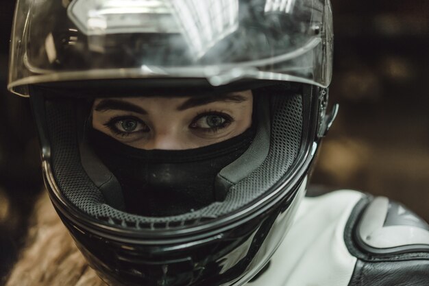 Hermosa chica con el pelo largo en el garaje reparando una motocicleta.