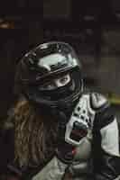 Foto gratuita hermosa chica con el pelo largo en el garaje reparando una motocicleta.